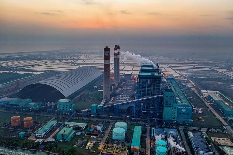 Aerial view of a power plant in Banten, Indonesia emitting smoke against a dusk sky. Used to visualize a common type of property which could benefit from a cost segregation study.