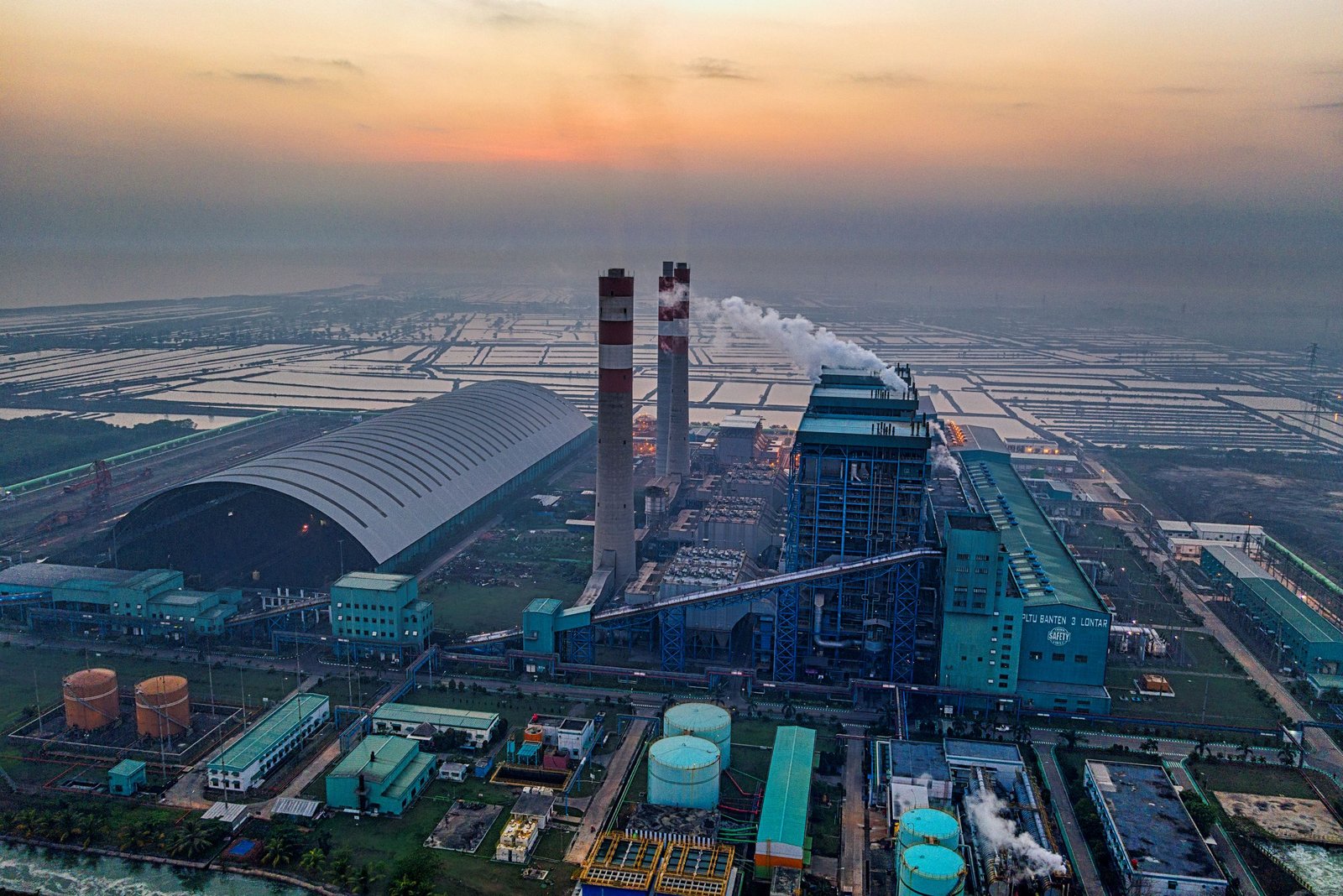 Aerial view of a power plant in Banten, Indonesia emitting smoke against a dusk sky. Used to visualize a common type of property which could benefit from a cost segregation study.